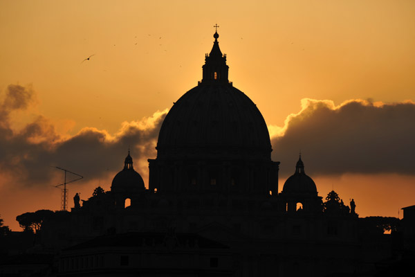 Silhouette of the dome of St. Peter's with an orange sky
