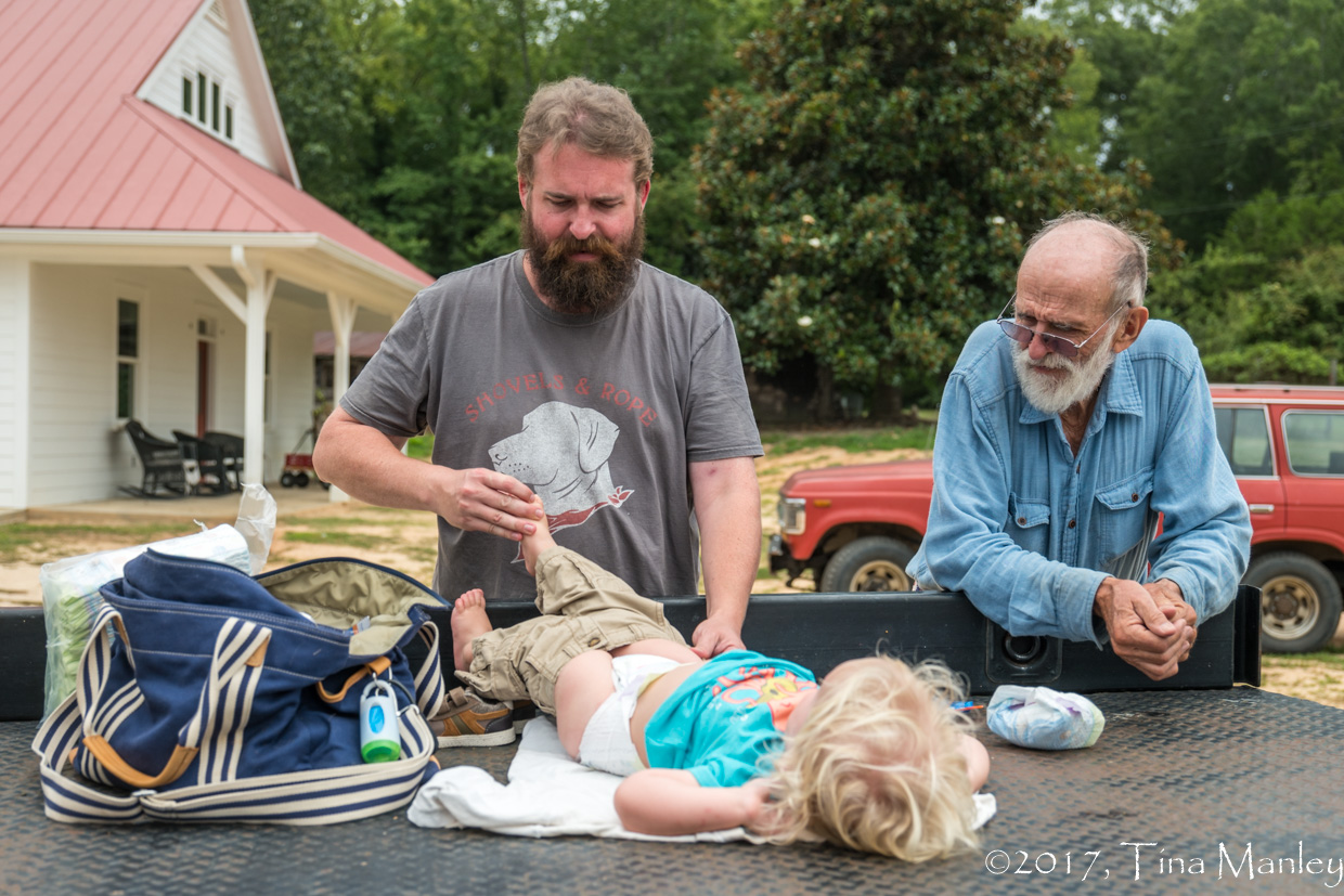 Just two guys changing a diaper on the flat-bed of a truck!