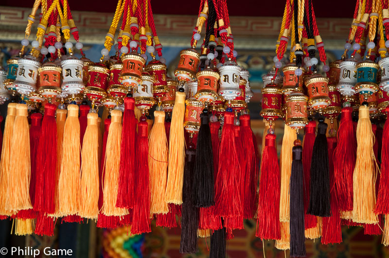 Colourful tassels decorate a selection of Buddhist prayer wheels
