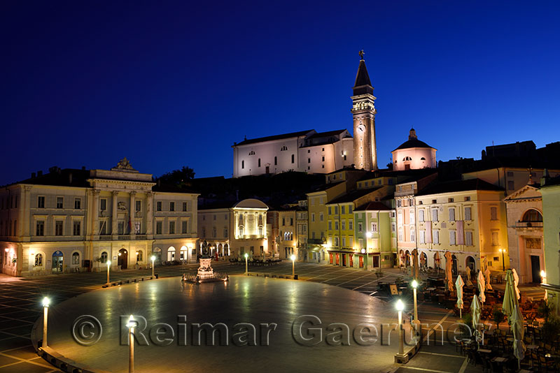 Empty Tartini Square in Piran Slovenia with City Hall, Tartini statue, St. Georges Parish Church with baptistry, and St Peters