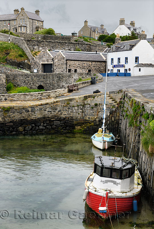 Moored boats and the Shore Inn at the Old Harbour with stone buildings of Portsoy Aberdeenshire Scotland UK
