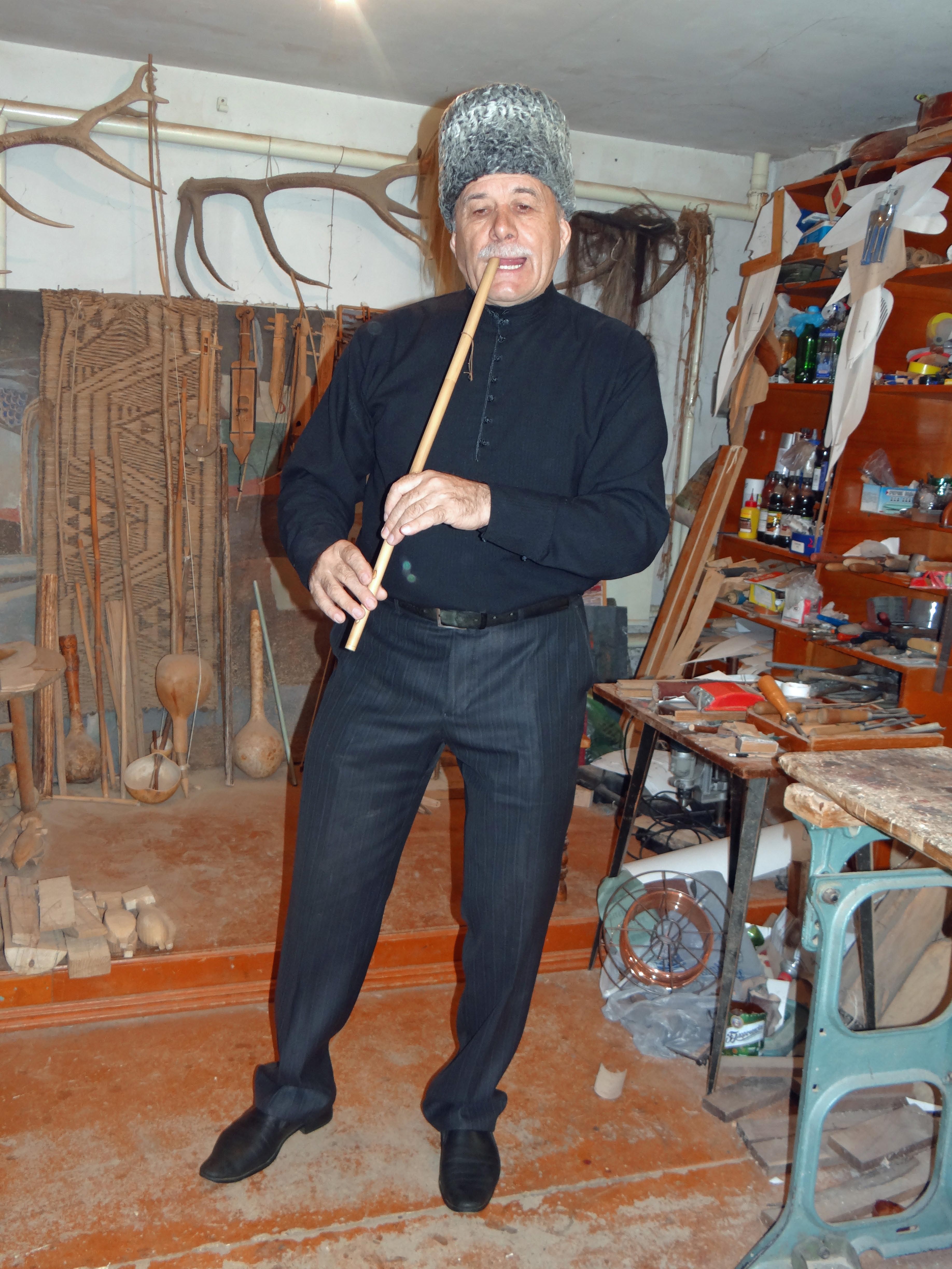 This is an instrument maker in Maykop; he has this flute anchored on a tooth!  Never have I seen this before, but it works.