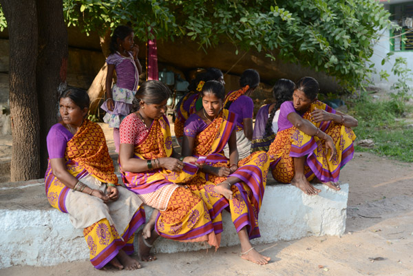 A group of woman with matching saris