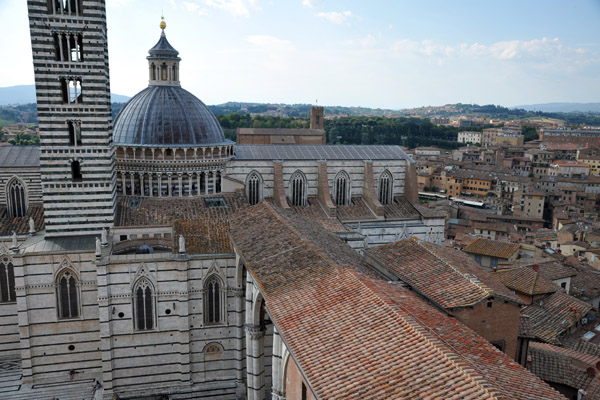 The dome and tower of Siena Cathedral with the roof of the Museo dell'Opera