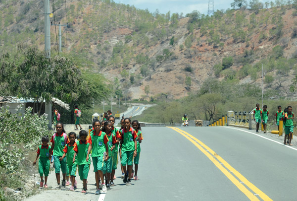 Timorese school children walking along the coastal road