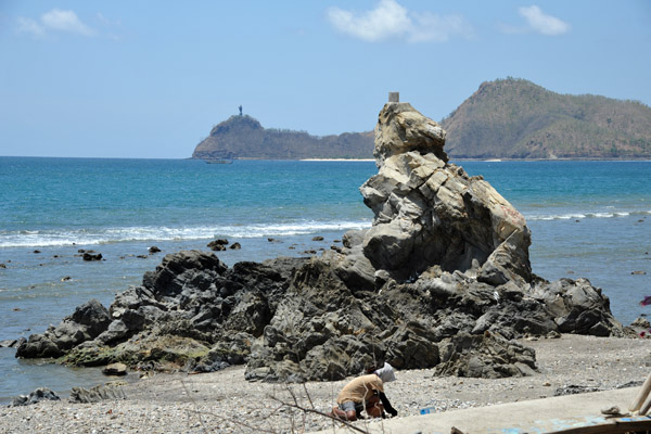 A stone collector at work near Dili with Cristo Rei in the distance