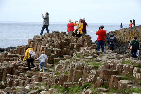 Tourists atop the basalt pillars of Giant's Causeway