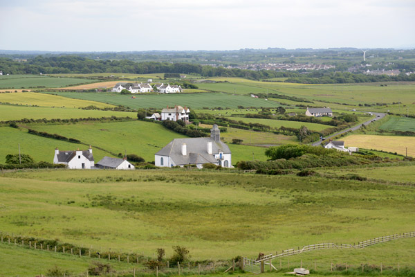 Old farmhouses and green fields adjacent to Giant's Causeway