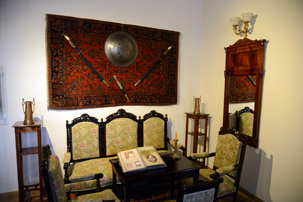 Sitting room in Mir Castle with a Persian carpet and Ottoman weapons