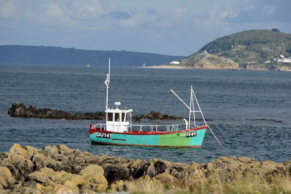 Guernsey fishing boat with the neighboring islands of Jethou and Sark