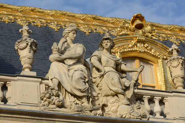 A pair of sculptures on the top level of the north wing, Palace of Versailles