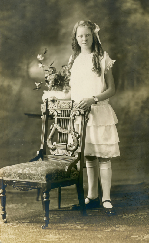 Girl standing by a chair  