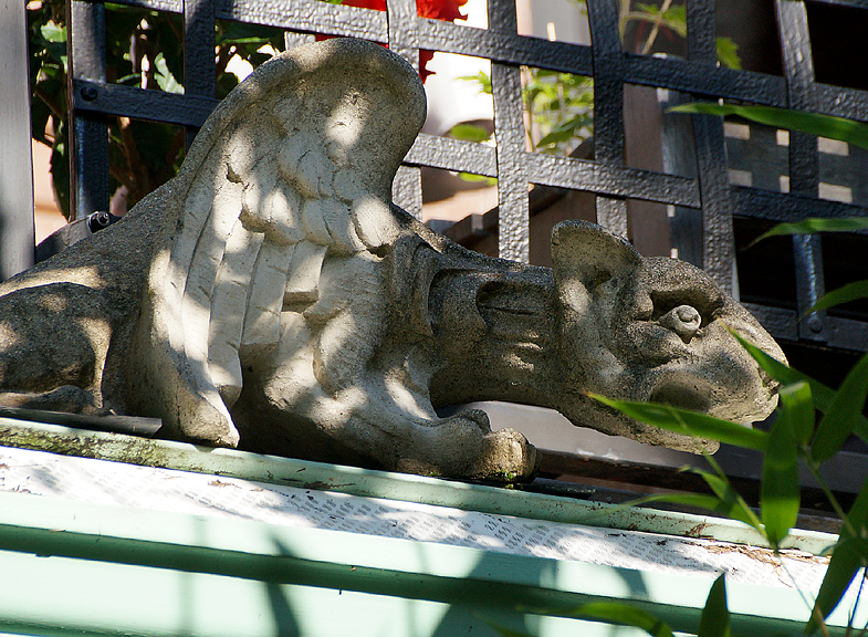 Gargoyle crouching on roof.
