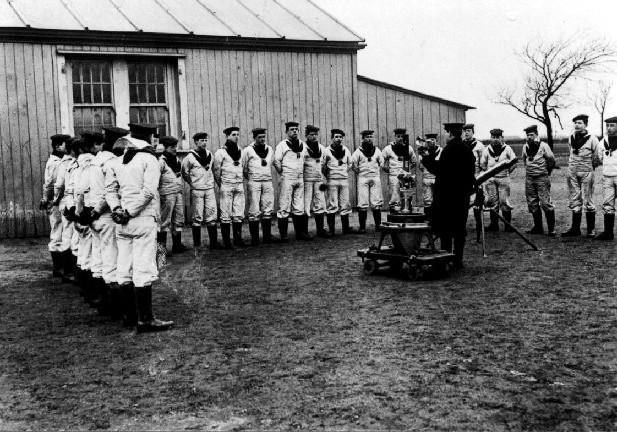 UNDATED - DICKIE DOYLE, MACHINE GUN INSTRUCTION, NOTE BUILDING IN BACKGROUND WHICH APPEARS IN MANY SUCH SLIDES-PHOTOS.jpg