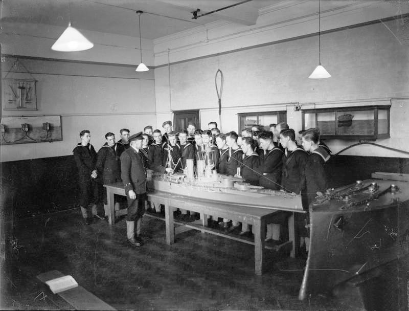 1940-1945 - HO RATINGS UNDERGOING TRAINING AROUND A MODEL BATTLESHIP.jpg