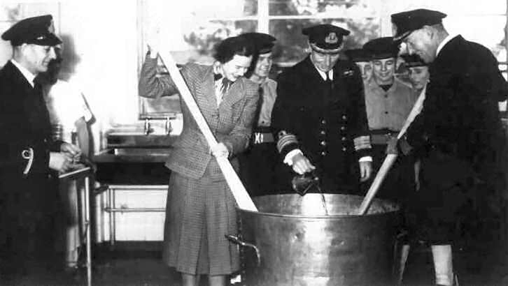1952, FEBRUARY - BUNGY WILLIAMS, CAPT. AND MRS. WHITFIELD, STIR XMAS PUD IN NEW CMG.jpg