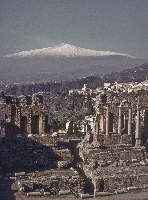 Mt Etna rises up beyond the ancient Greek theatre at Taormina, Sicity