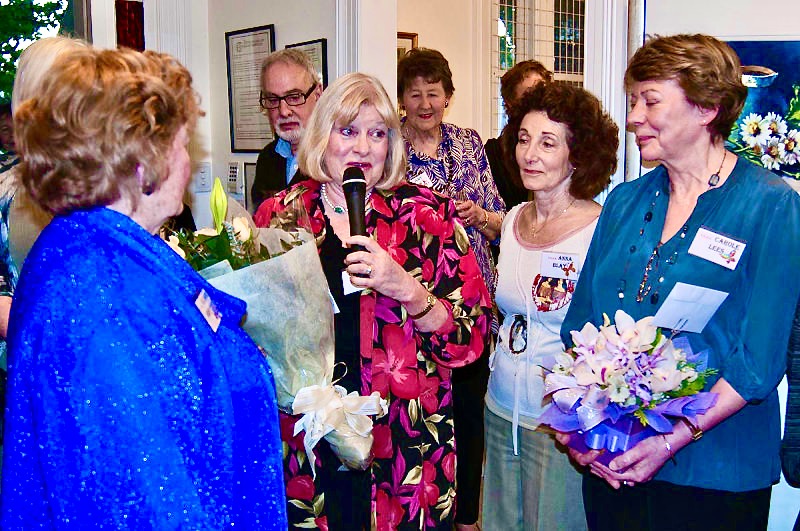 Barb presents flowers to Eleanor on behalf of the group