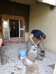 Tradesman at work mixing stucco, prior to exterior painting