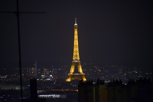 The Eiffel Tower illuminated at night as seen from Montmartre