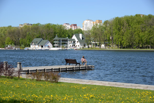 Man fishing from a dock in the Svislach River, Victory Park, Minsk
