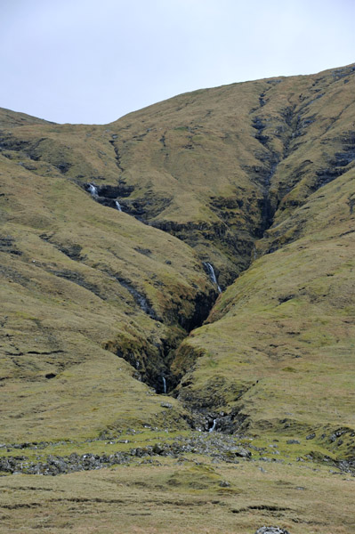 Stream with waterfalls cutting into the hillside
