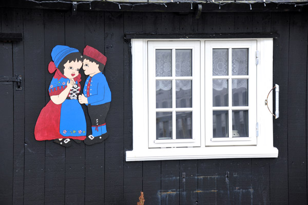 Traditional costumes on the side of a house in Gjgv
