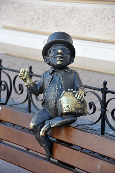 Sculpture of a small man in a hat perched on a bench, Odessa