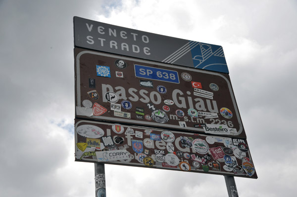 The sign at Giau Pass covered with stickers, mostly from cycling clubs