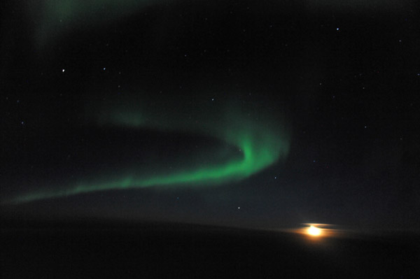 Aurora Borealis over northern Canada with a full moon rising