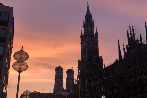 Pink sky silhouetting the Rathaus and Frauenkirche, Marienplatz