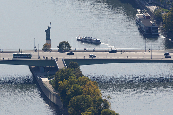 Tourist boat making a turn around the little Statue of Liberty