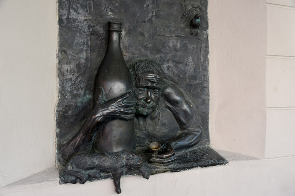 Sculpture of a man hugging a giant wine bottle