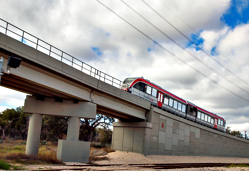 An  Austin, Tx  Capital Metro light rail car moves up an incline 