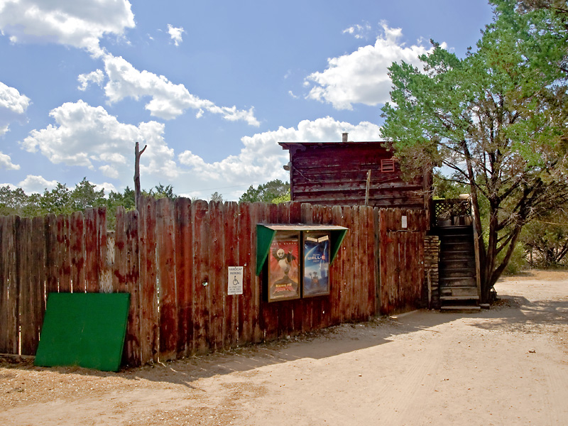 The outside of  the theater showing the fence which surrounds it and the projection  booth.