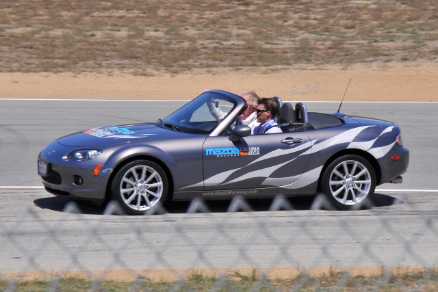 Dan Gurney, 79, being driven by son Alex around the Mazda Raceway Laguna Seca in a Mazda MX-5 Miata. (CR)