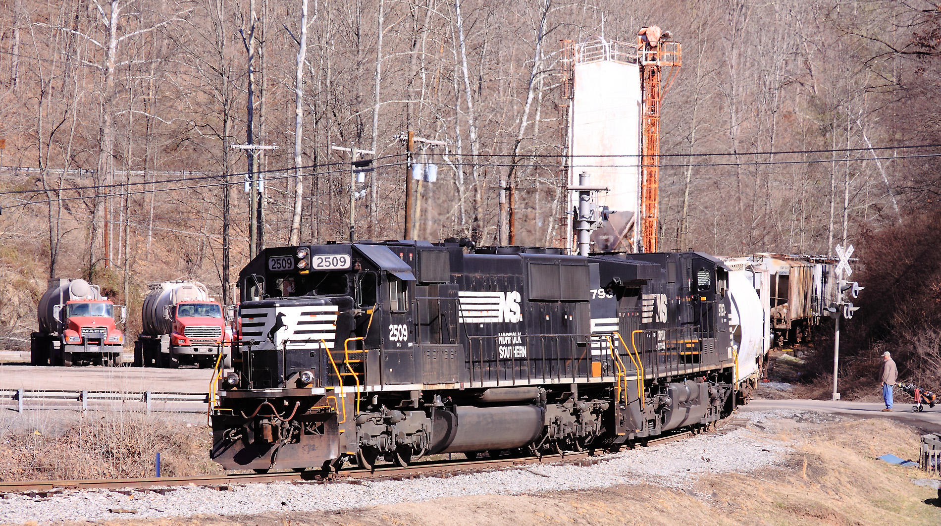 A local is spotting cars on the Tug Fork branch, while a golfer waits to cross the tracks to the next hole. 