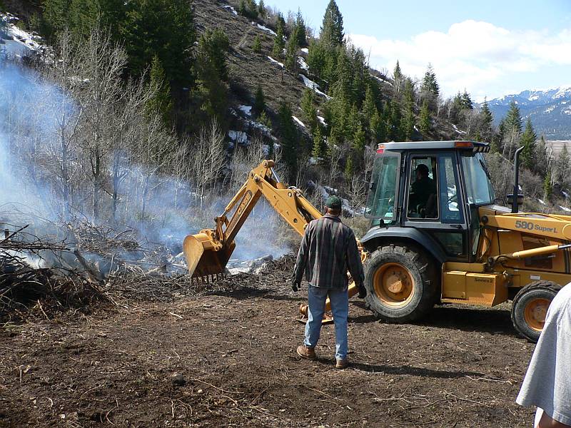 Tim using backhoe to speed up fire
