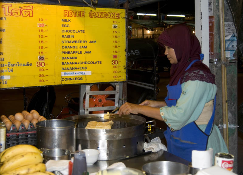 Muslim woman cooking roti