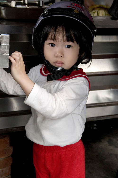 Helmet-clad infant at a snack stall