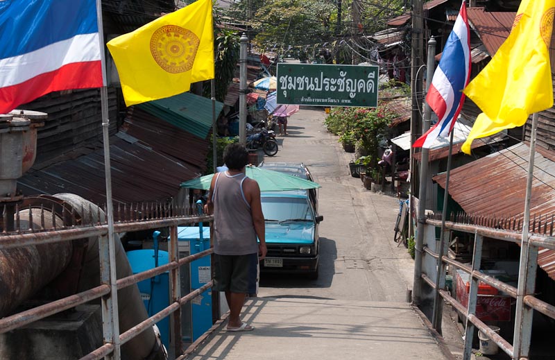 A footbridge leads down from the khlong