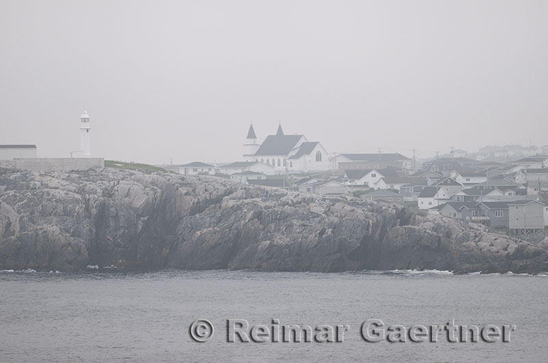 Channel Port aux Basques Newfoundland lighthouse and Anglican church from the coast in fog