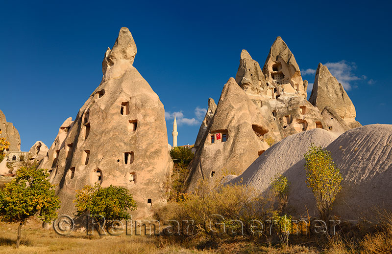 Ancient cave houses carved out of volcanic tuff at Uchisar with evening sun Cappadocia Turkey