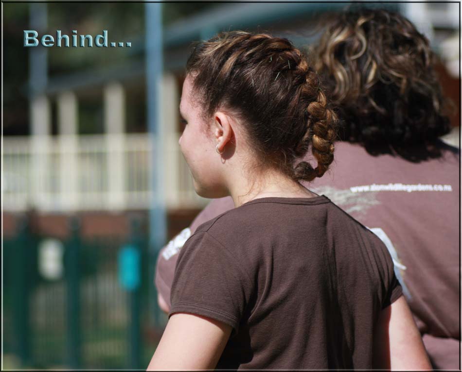 Behind 