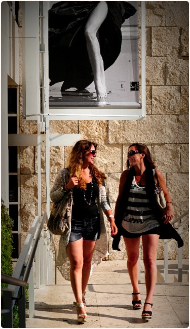 Two Women Beneath a Poster at the Getty Center