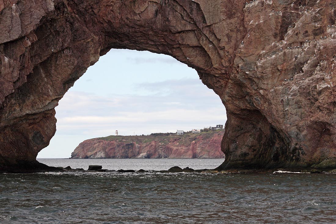 Phare du Cap Blanc through Perce rock.jpg