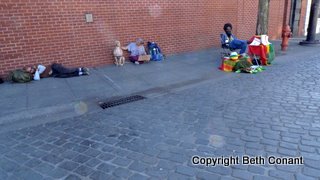 more homeless rest on the sidewalk.