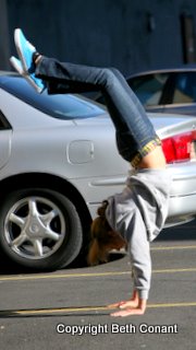 Handstands in the parking lot kill time as she waits.