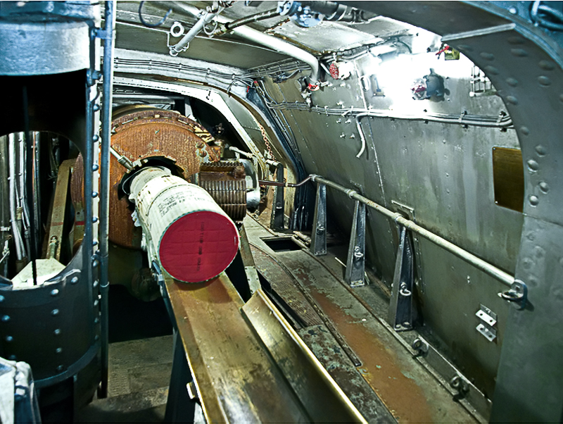 Inside a gun turret: Loading 104 pound bags of powder into breach of 14 inch gun.  Full charge= 4 bags.