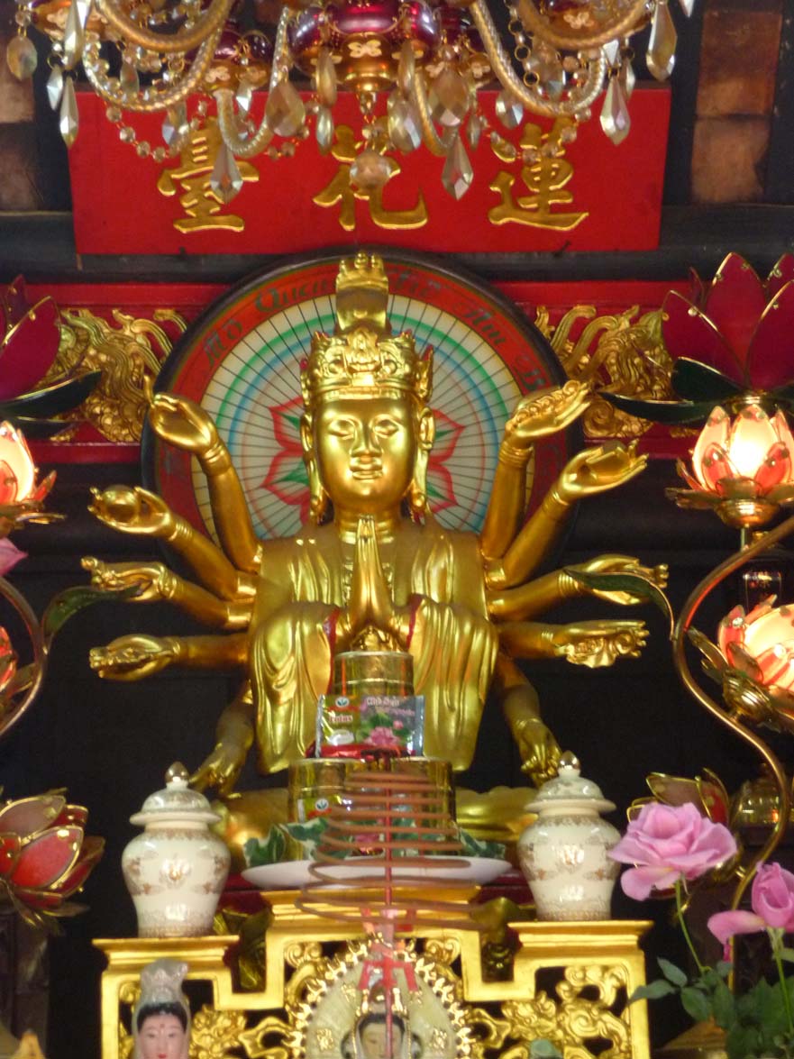 Close-up of the golden multi-armed Buddha inside of the pagoda.
